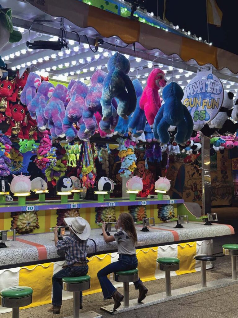 two children play a carnival game at the Greeley Stampede